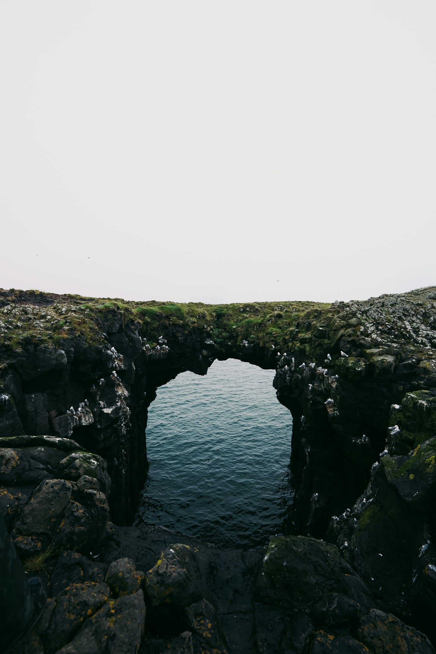 Sea arch of dark rock over the water