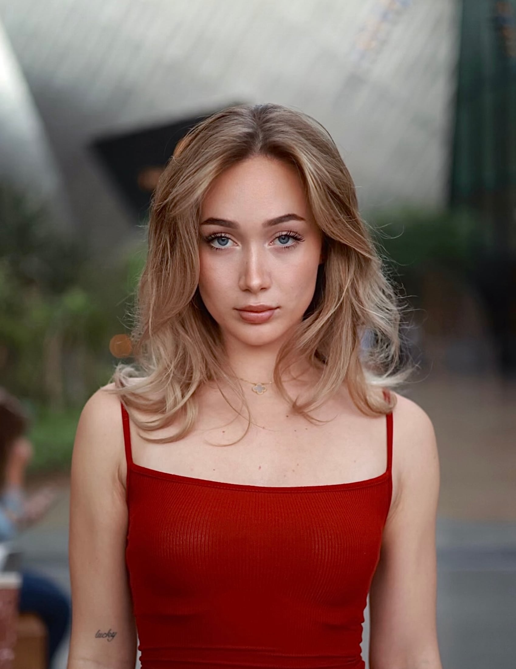 Portrait in a red dress against a curved steel wall